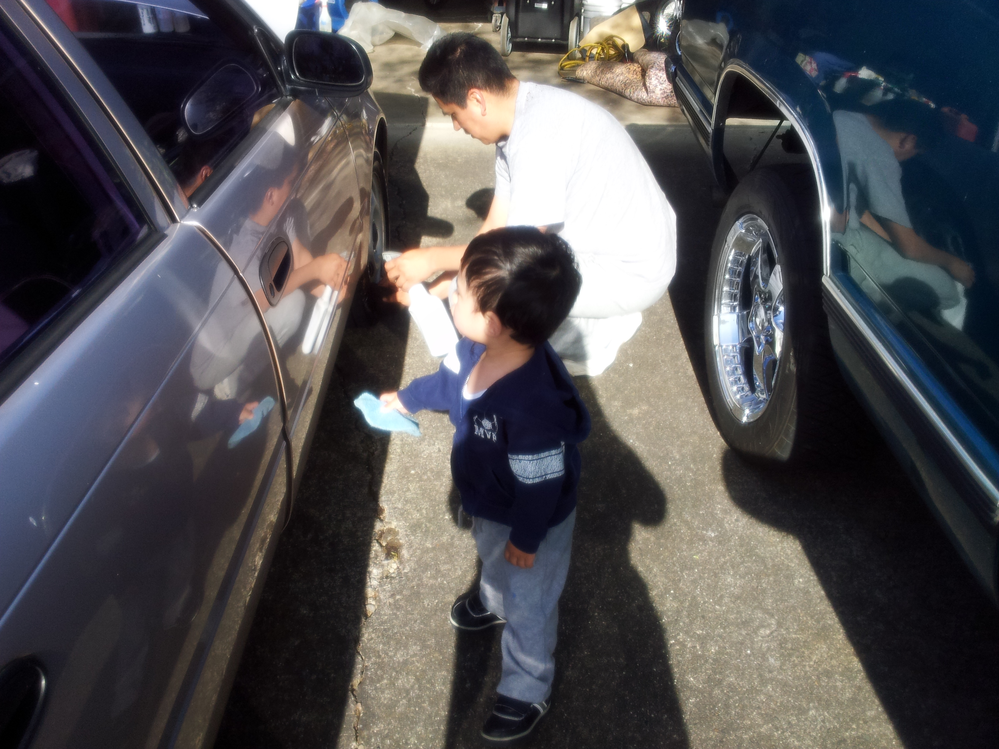 Family members washing a car together at Safe Auto Detail